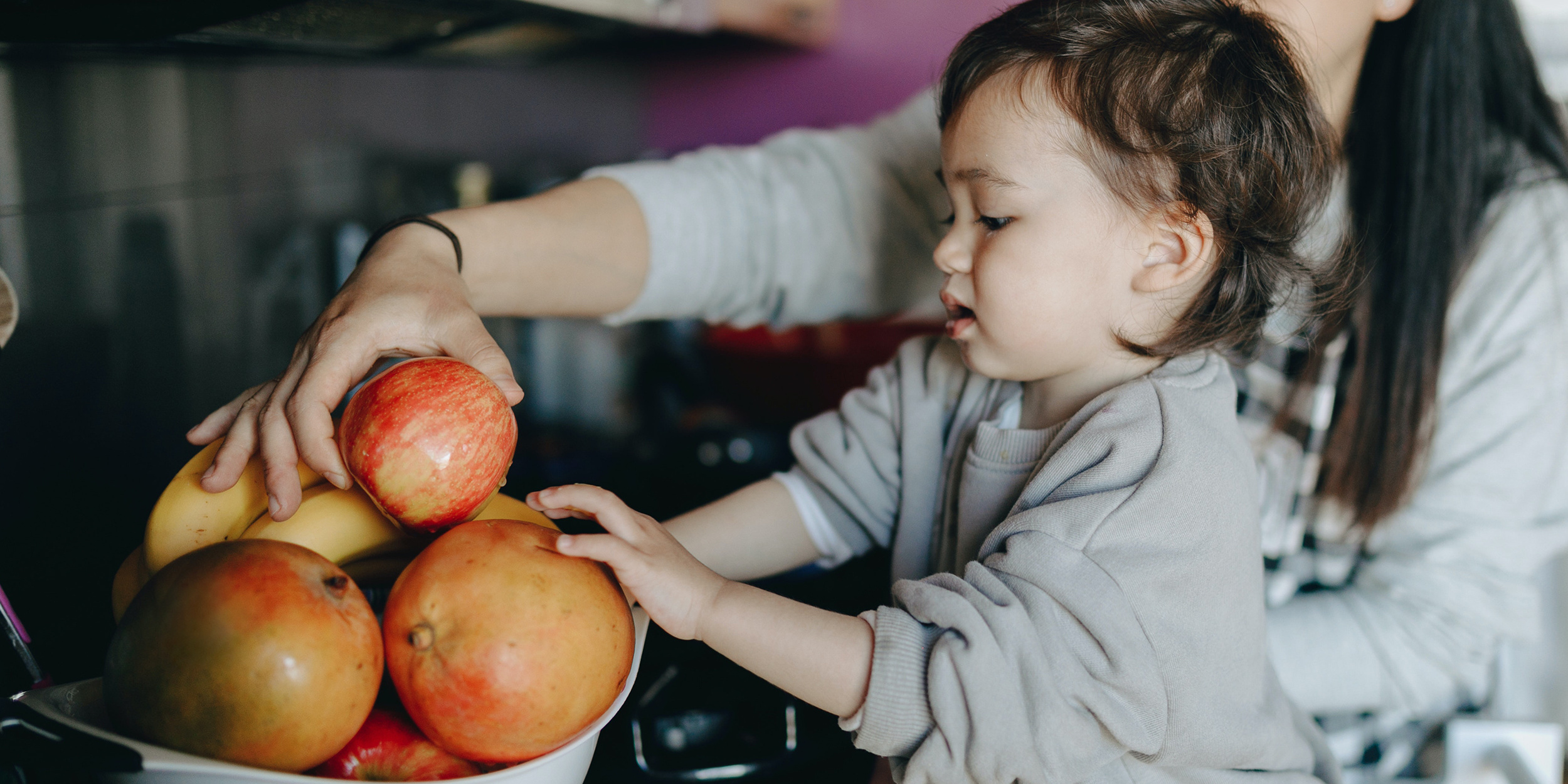 Alete bewusst Kleinkind greift nach Äpfeln