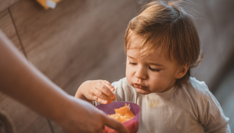 Alete bewusst Kleinkind beim Naschen von Obst