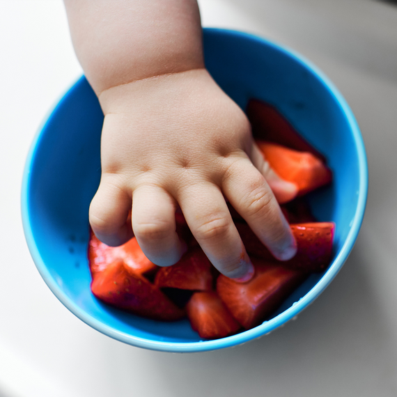 Kinderhand greift nach Erdbeeren